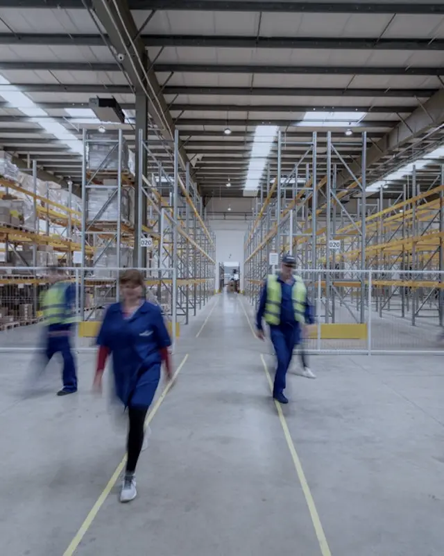 Staff walking through a busy e-commerce warehouse