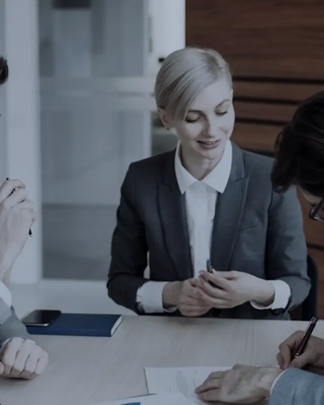 A professional in a meeting, reviewing documents at a desk